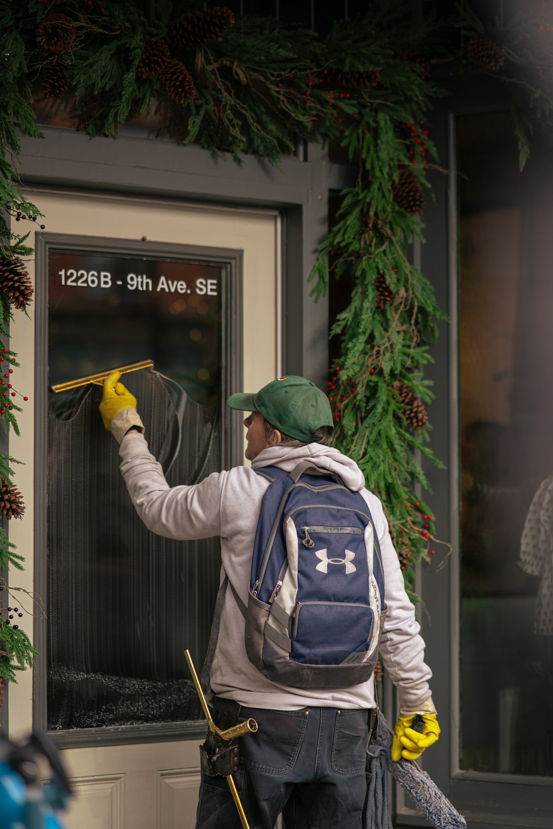 man-cleaning-a-storefront-window-with-a-squeegee-mg29fmiyng0